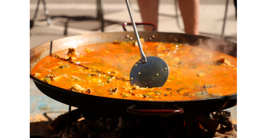 How does altitude and climate affect the cooking of paella?