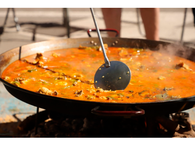 How does altitude and climate affect the cooking of paella?